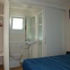 Bagno compatto con WC, lavabo e doccia, letto a sinistra.