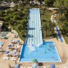 Scivolo acquatico con piscina e bagnanti intorno.