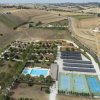 Vista dall'alto di piscine e campi da tennis in campagna.