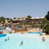 Piscina con giochi d'acqua colorati e lettini.