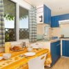 Cucina con tavolo apparecchiato e mobili blu.