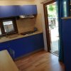 Cucina con pensili blu e porta aperta verso l'esterno.