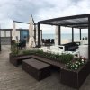 Area lounge sulla spiaggia con sedute e pergolati.