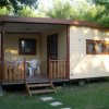 Casa mobile con veranda e sedie bianche su prato.