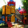 Parco giochi colorato a forma di castello con scivoli.