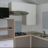 Cucina moderna con elettrodomestici e tv.