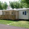 Casa mobile con veranda in legno e giardino.