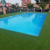 Piscina rettangolare circondata da erba.