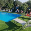 Piscina esterna con sdraio e persone a bordo vasca.