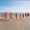 Persone in costume da bagno formano un cerchio tenendosi per mano nell'acqua.