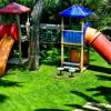 Un'area giochi con scivoli colorati e una struttura rampicante su un prato verde.