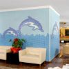 Area salotto in hotel con murale di delfini e divani bianchi.