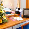 Specchio, fiori e TV su un tavolo da toeletta in camera da letto.