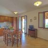 Cucina con tavolo apparecchiato, porta aperta e finestra con vista.