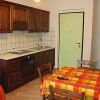 Cucina con mobili in legno e tavolo con tovaglia a quadri colorati.