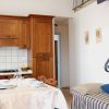 Cucina con mobili in legno, tavolo apparecchiato e una scala a chiocciola.