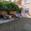 Giardino con tavolo e sdraio sotto un albero.