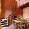 Soggiorno con scala in legno, tavolo e divano.