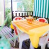 Terrazza con tavolo arancione, sedie bianche.
