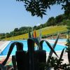 Piscina con vista su colline e ombrelloni.