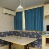 Tavolo con sedute imbottite e tenda blu.
