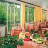 Sala da pranzo con tavoli imbanditi e vista su giardino.