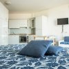 Camera con letto, cucina e TV a muro.