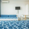 Letto e divano blu in stanza luminosa.