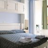 Camera da letto con mobili bianchi, letto matrimoniale e asciugamani piegati.