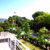 Collage di un edificio moderno con giardino recintato, vialetto e balconi.
