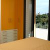 Camera da letto con armadio arancione e porta aperta su un terrazzo con vista panoramica.