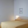 Camera da letto con letto matrimoniale e copriletto giallo, soffitto in legno.
