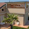 Villa moderna vista mare con giardino e palme.