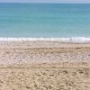 Spiaggia con sabbia e mare calmo all'orizzonte.