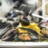 Piatto di cozze con pasta su un tavolo.