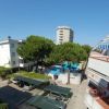 Complesso residenziale con balcoini e piscina, circondato da alberi.