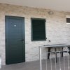 Balcone con porta verde e tavolo.