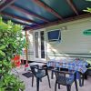 Veranda di una casa mobile con tavolo apparecchiato e sedie.