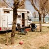 Camper parcheggiato vicino ad alberi e mare.